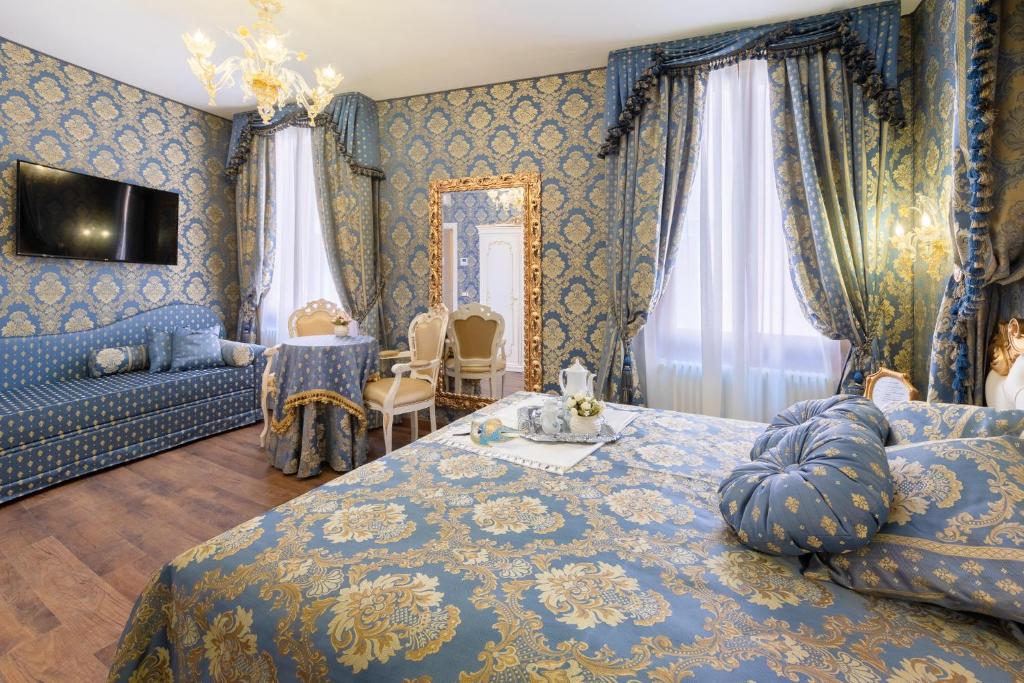 a blue bedroom with a bed and a living room at Canal View San Marco Luxury Rooms in Venice