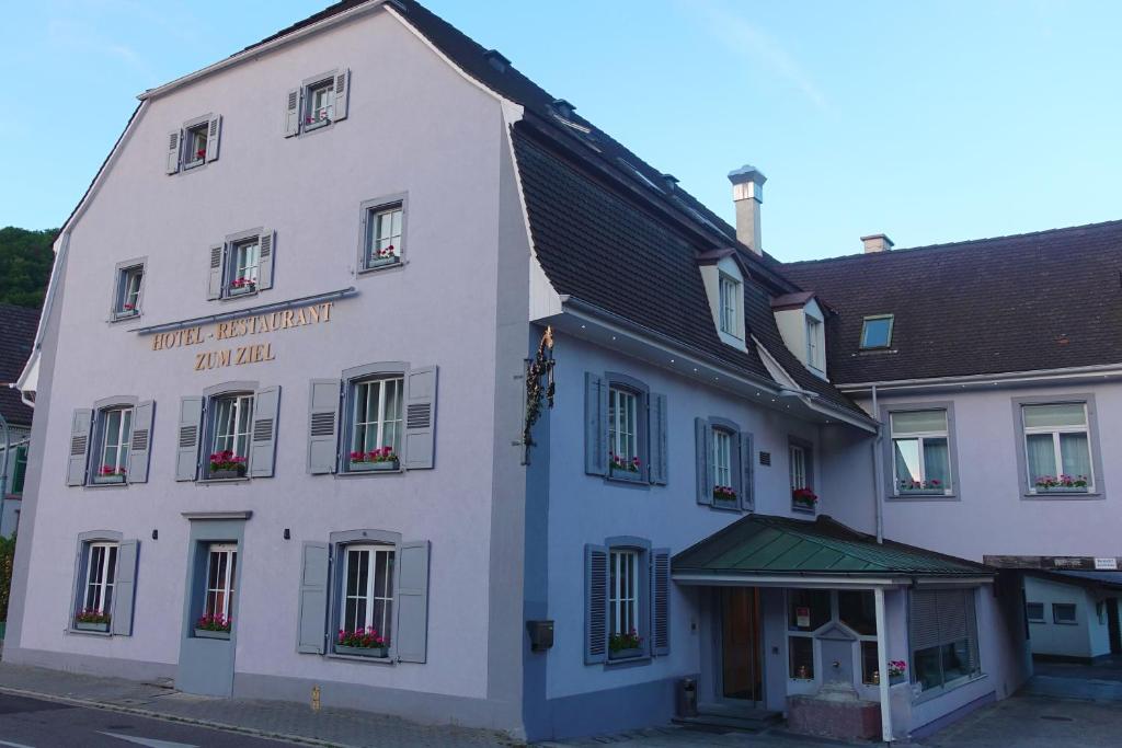 ZUM ZIEL Hotel & Restaurant Grenzach-Wyhlen bei Basel في غرنزاش ويلن: مبنى ابيض وزرق على جانب شارع