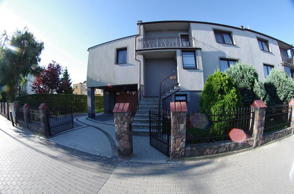 a house with a fence in front of it at Pokoje gościnne U Jadzi in Chałupy