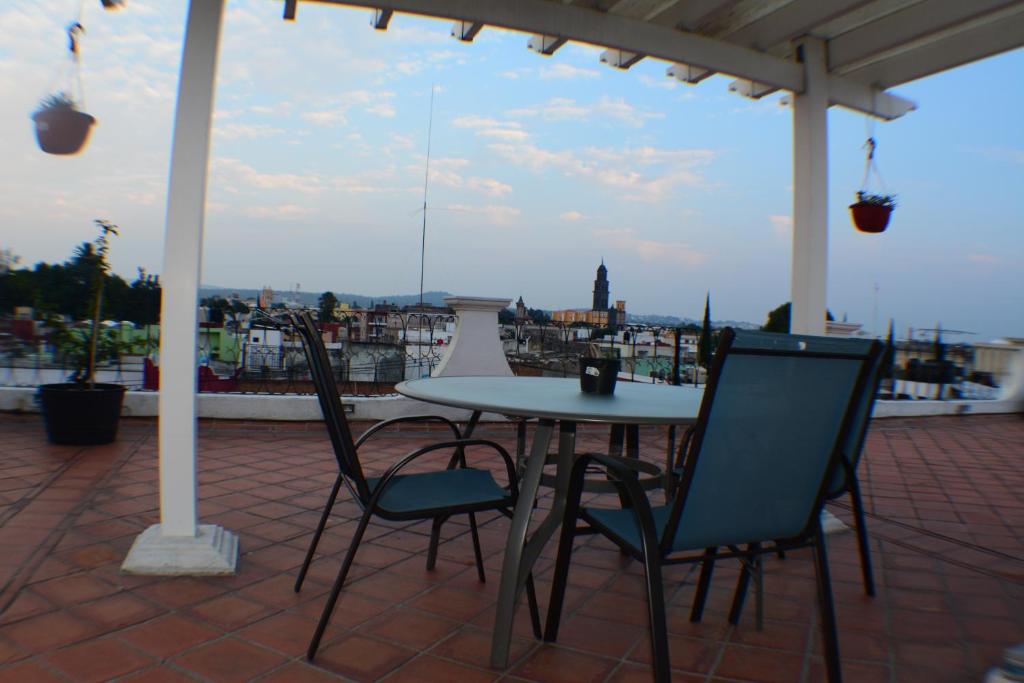 a table and chairs on a patio with a view of a city at HOTEL DEL CAPITAN DE PUEBLA, DEPARTAMENTOS in Puebla