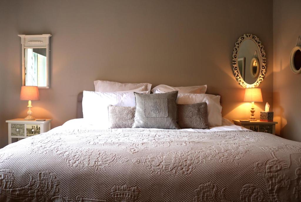 1 dormitorio con cama blanca con almohadas y espejo en Mortimer Trail B and B en Aymestrey