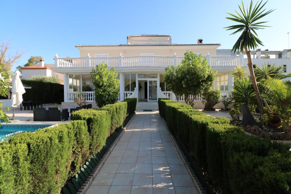ein großes weißes Haus mit Hecken davor in der Unterkunft Villa de lujo en Torremolinos in Torremolinos