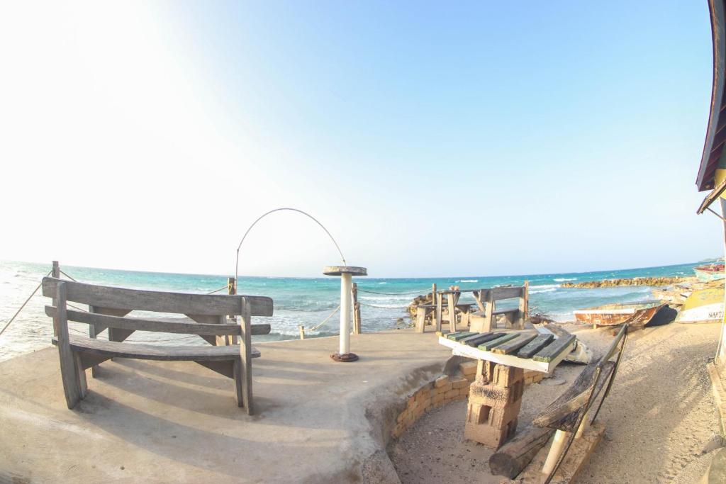 a group of benches sitting on the beach at One Rythm-Beach Villa in Silver Sands