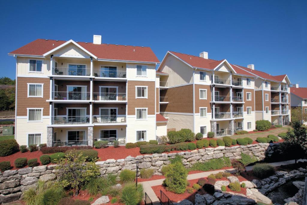 una fila de edificios de apartamentos con una pared de piedra en Club Wyndham Mountain Vista, en Branson