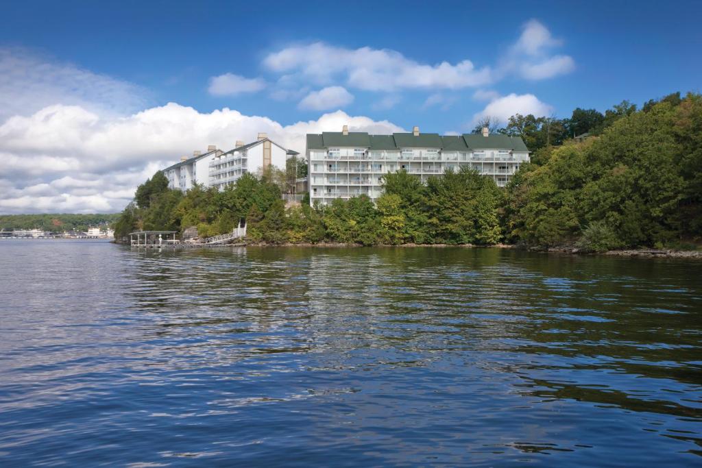 ein großer Wasserkörper mit einem Gebäude im Hintergrund in der Unterkunft WorldMark Lake of the Ozarks in Osage Beach