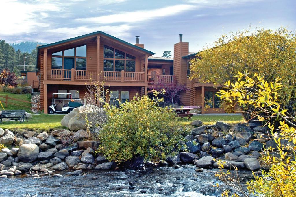 a house with a river in front of it at WorldMark Estes Park in Estes Park