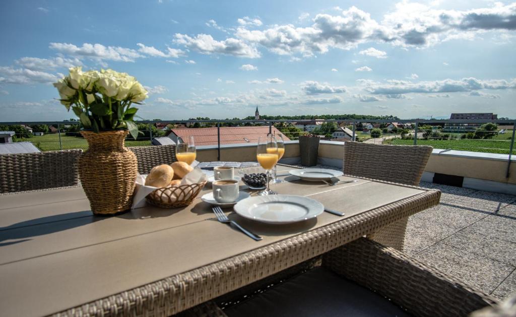 a table on a balcony with a view of the city at Apartmaji Aida in Moravske Toplice