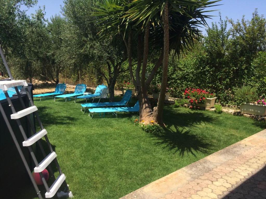 a group of blue lounge chairs sitting in the grass at Villa Levanta in Arménoi