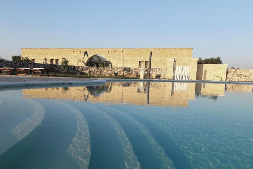 a pool of water in front of a building at Agriturismo Le Site in Corigliano dʼOtranto