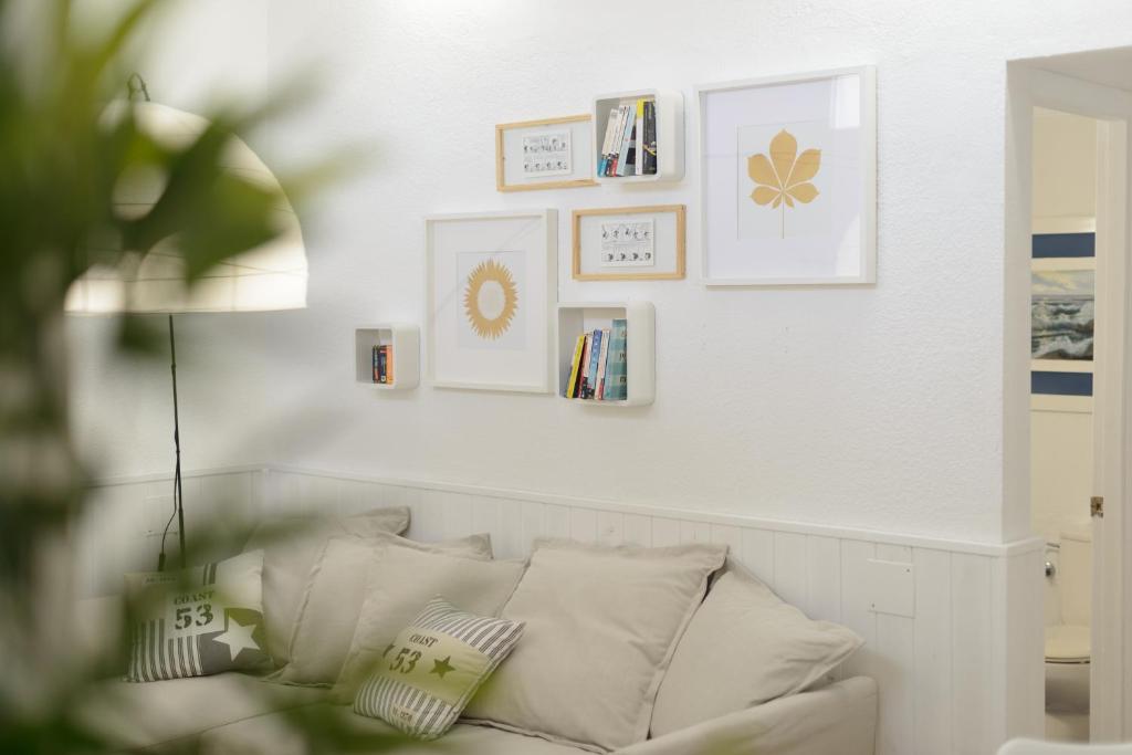 - un salon blanc avec un canapé blanc et des photos encadrées dans l'établissement ACOGEDORA CASITA CERCA DEL MAR, à La Garita