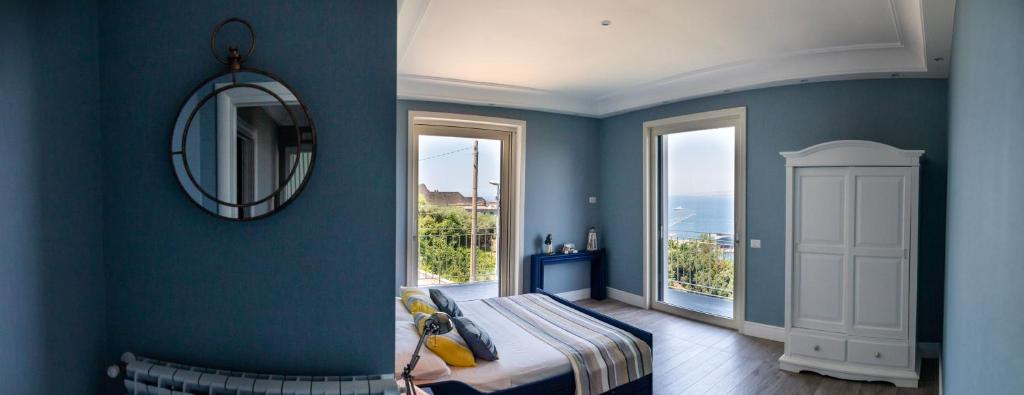 a blue room with a bed and a mirror at Le Fratte Luxury Home in Castellammare di Stabia