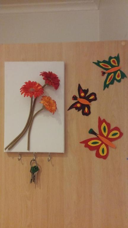 a painting of a flower on a wall with butterflies at Studio Telheiras in Lisbon