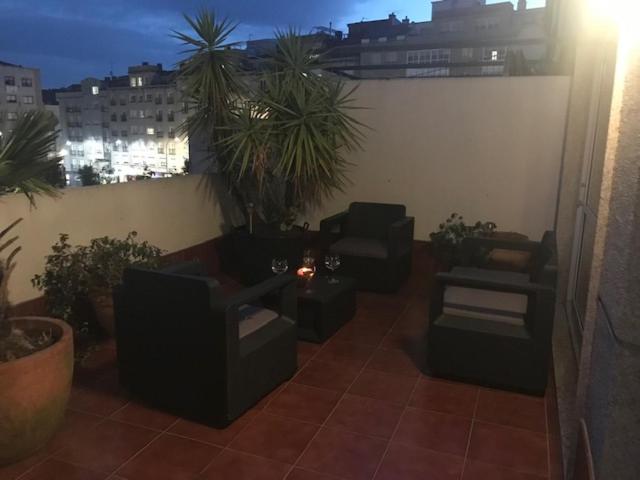 un balcón con sofás y plantas en un edificio en HyP - El Oasis del Centro, en Pontevedra