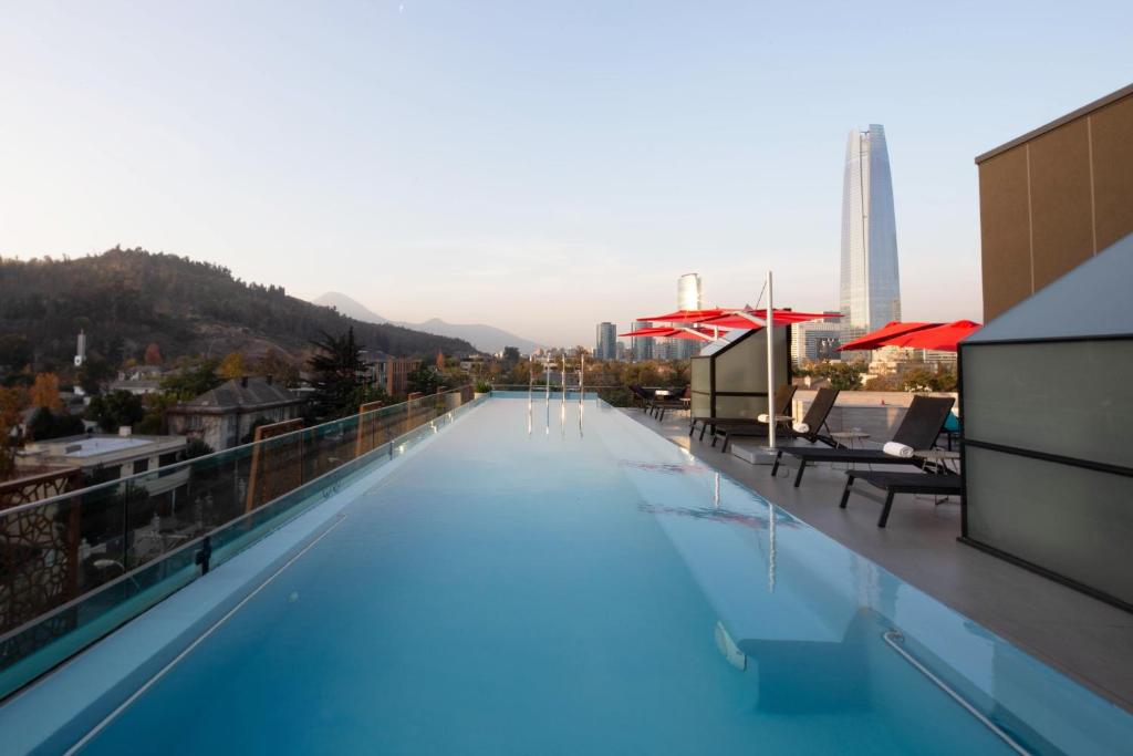 
a pool with a balcony overlooking a city at Ladera Boutique Hotel in Santiago

