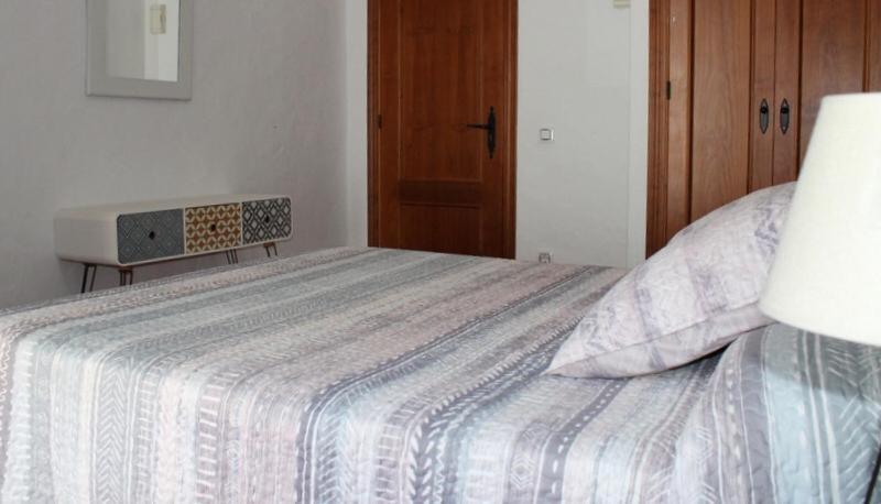 a bedroom with a bed with a striped comforter at Hostal El Espinel in Zahara de los Atunes