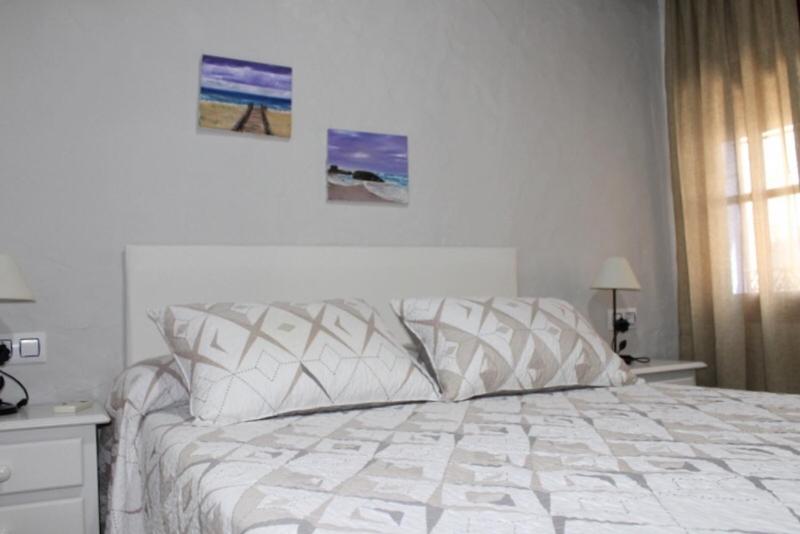 a bedroom with a bed with a white comforter at Hostal El Espinel in Zahara de los Atunes