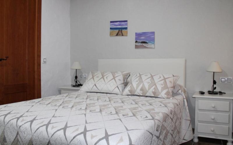 a white bed in a white bedroom with two night stands at Hostal El Espinel in Zahara de los Atunes