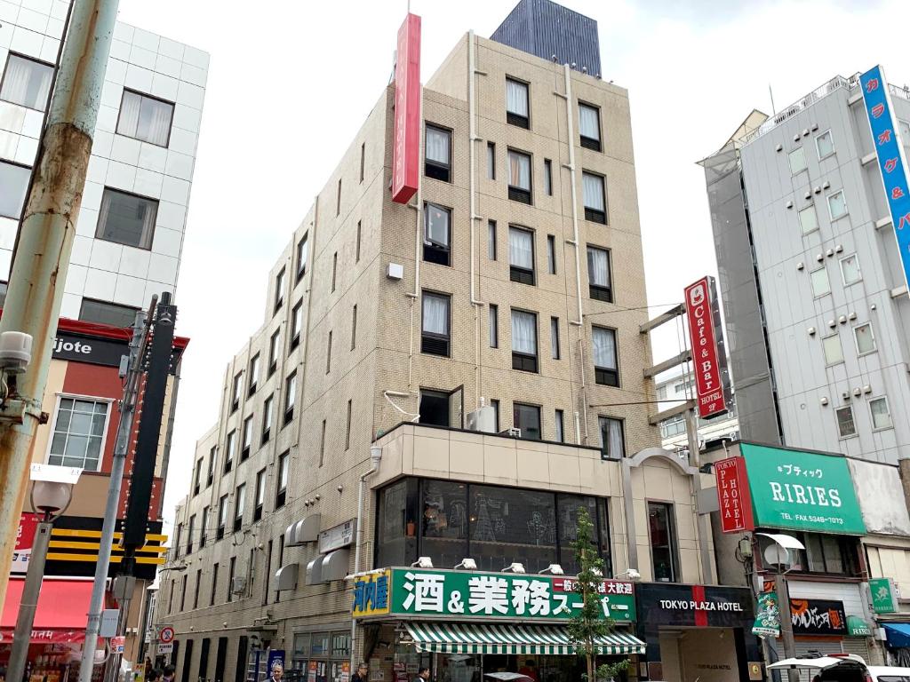 un edificio en una concurrida calle de la ciudad con edificios en Tokyo Plaza Hotel, en Tokio