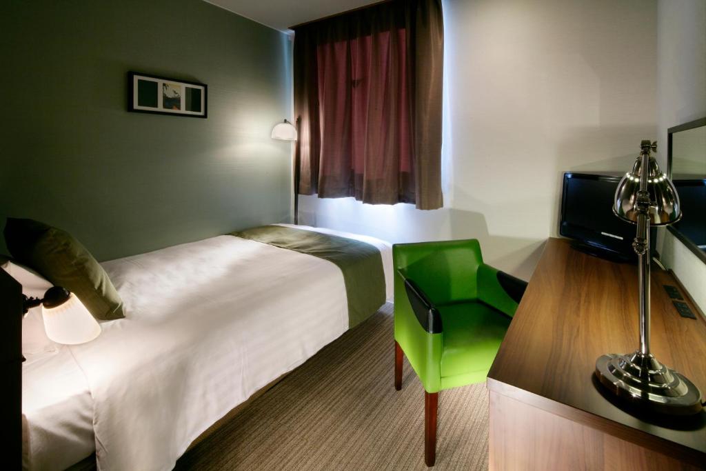 Tempat tidur dalam kamar di Hotel Quest Shimizu