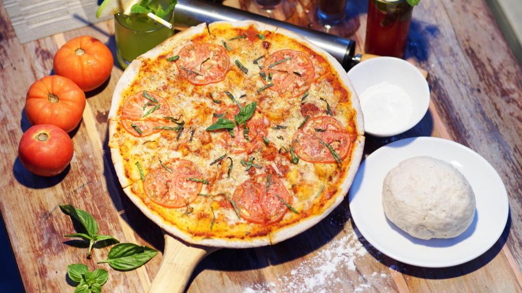 a pizza sitting on top of a wooden table at Cuna Hotel in El Nido
