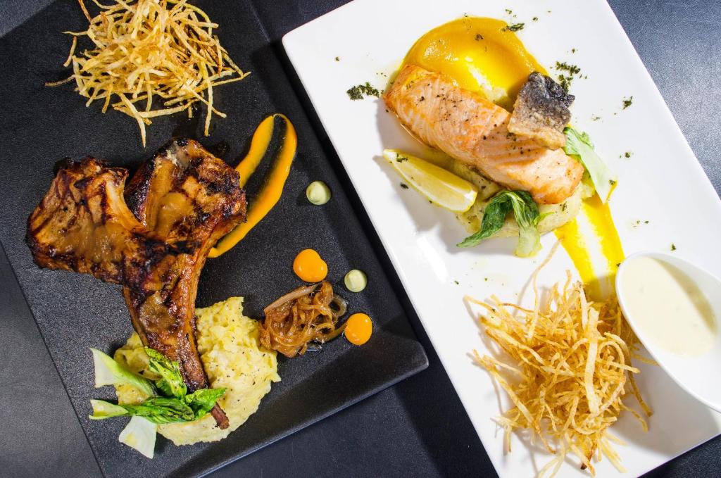 a plate of food with meat and vegetables on a table at Cuna Hotel in El Nido