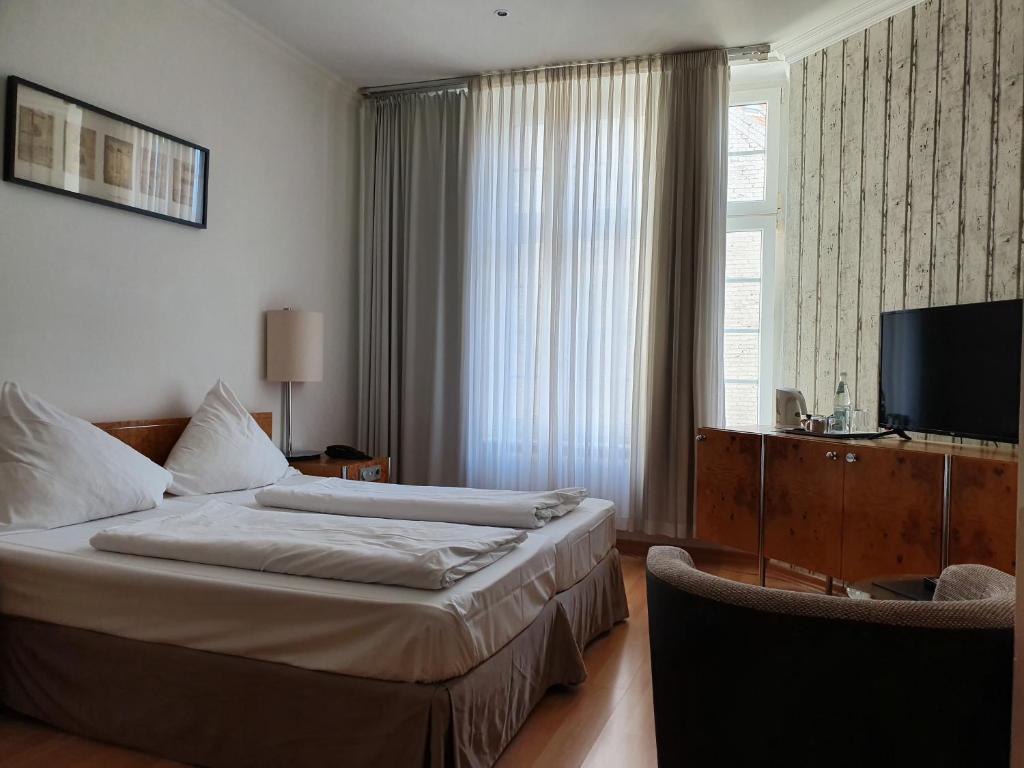 a hotel room with two beds and a television at Erlanger Hof in Berlin