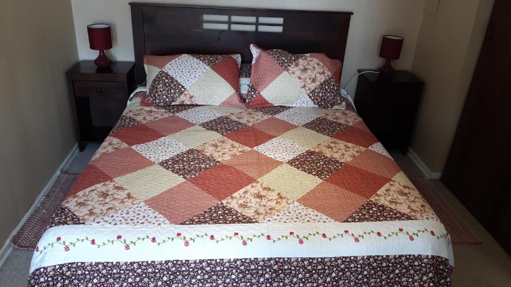 Una cama con manta y almohadas. en Departamentos Rohe, en Puerto Montt