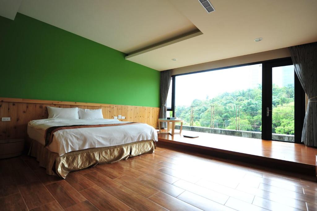 a bedroom with a bed and a green wall at Sun Moon Lake Karuizawa Villa in Yuchi