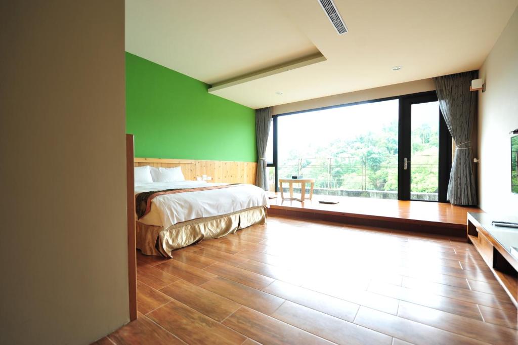 a bedroom with a bed and a green wall at Sun Moon Lake Karuizawa Villa in Yuchi