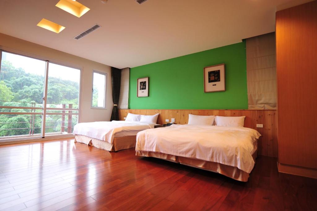 a bedroom with two beds and a green wall at Sun Moon Lake Karuizawa Villa in Yuchi
