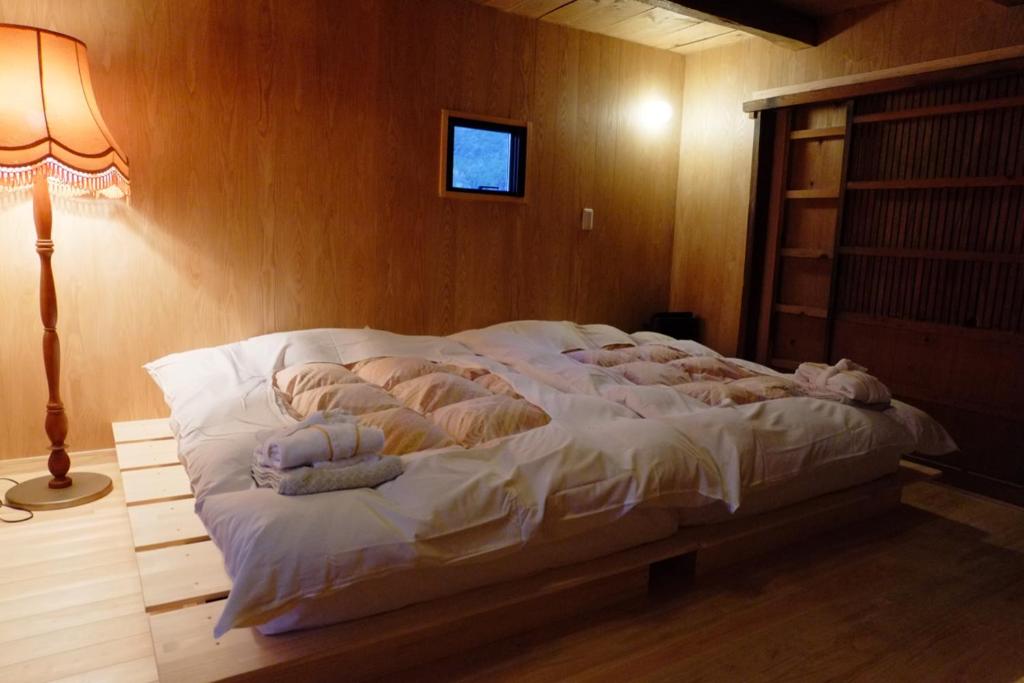 een slaapkamer met een bed met handdoeken erop bij 無鹿リゾート in Kokuryō