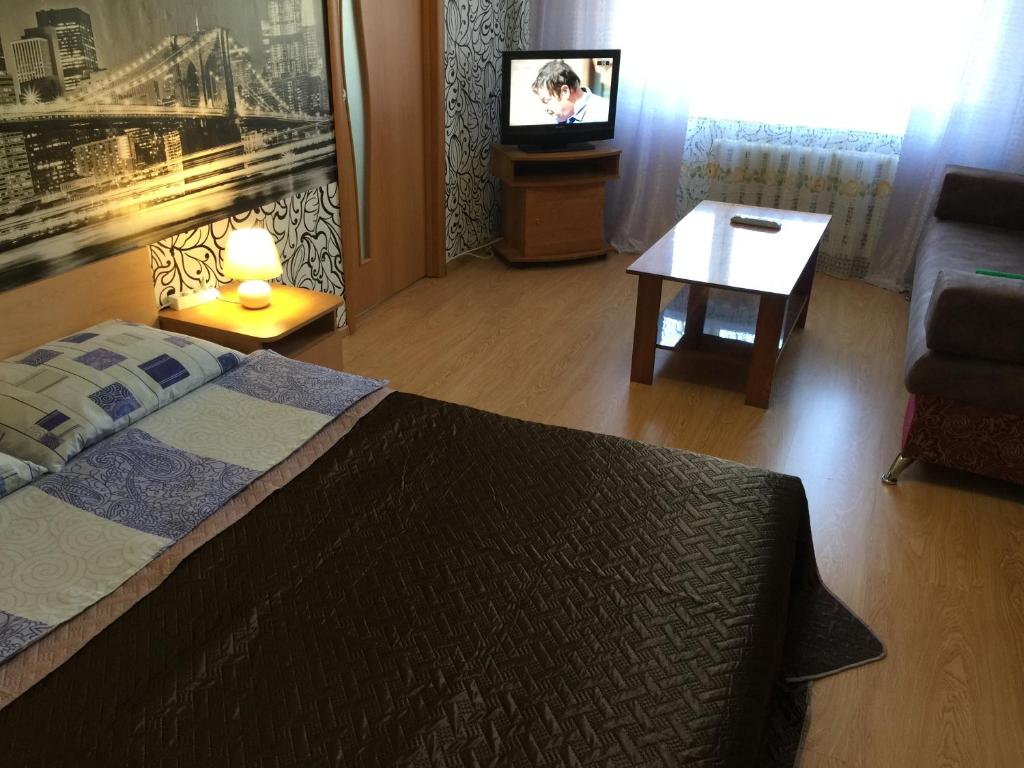 アンガルスクにあるАпартаменты LUX в центреのベッドルーム(ベッド1台、テーブル、テレビ付)