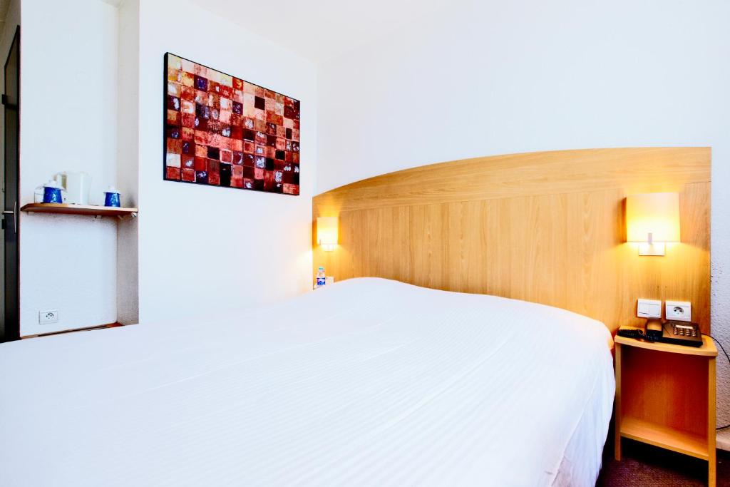Postel nebo postele na pokoji v ubytování Hôtel Restaurant Kyriad Mulhouse Nord Illzach
