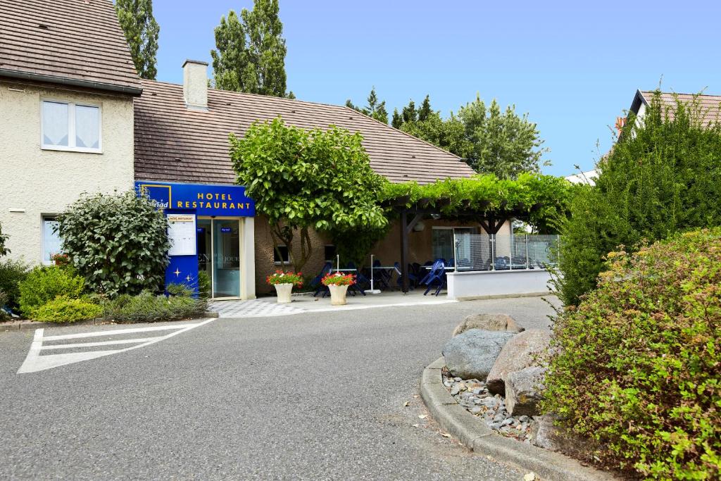 une rue en face d'un bâtiment dans l'établissement Hôtel Restaurant Kyriad Mulhouse Nord Illzach, à Illzach