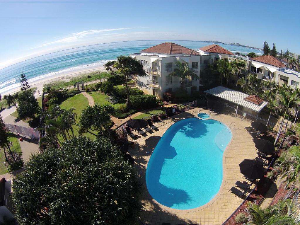 una vista aérea de un complejo con piscina y playa en Golden Riviera Absolute Beachfront Resort en Gold Coast