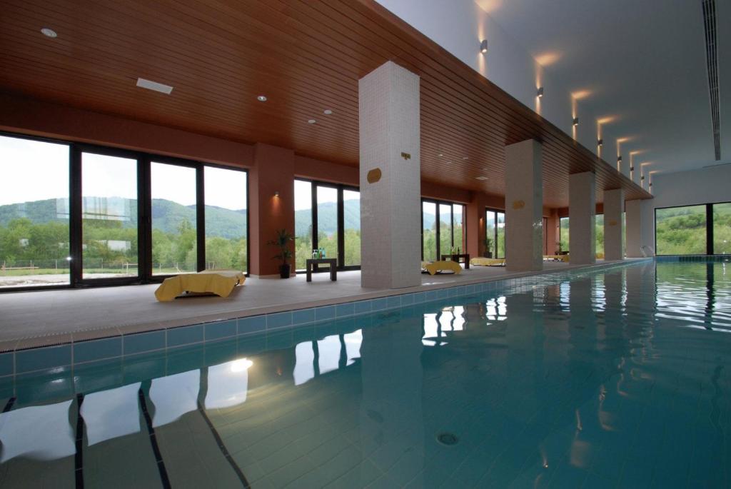 a large swimming pool in a building with windows at New Wolf in Bran