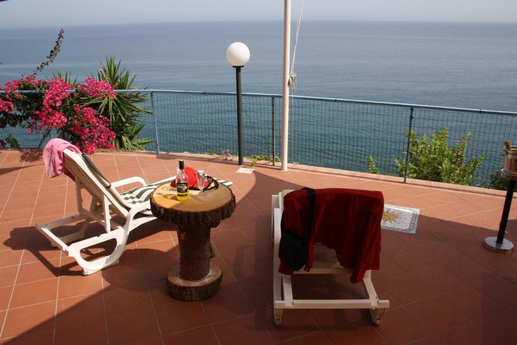 un patio con tavolo e sedie sul balcone. di Camere & Case Vacanze Lo Scoglio a Castel di Tusa