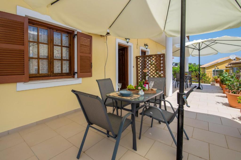 a table and chairs with an umbrella on a patio at Voula Apartments in Gaios