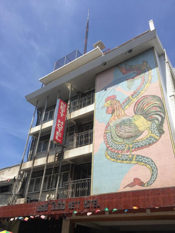 a building with a painting of a rooster on it at Nett Hotel in Lop Buri