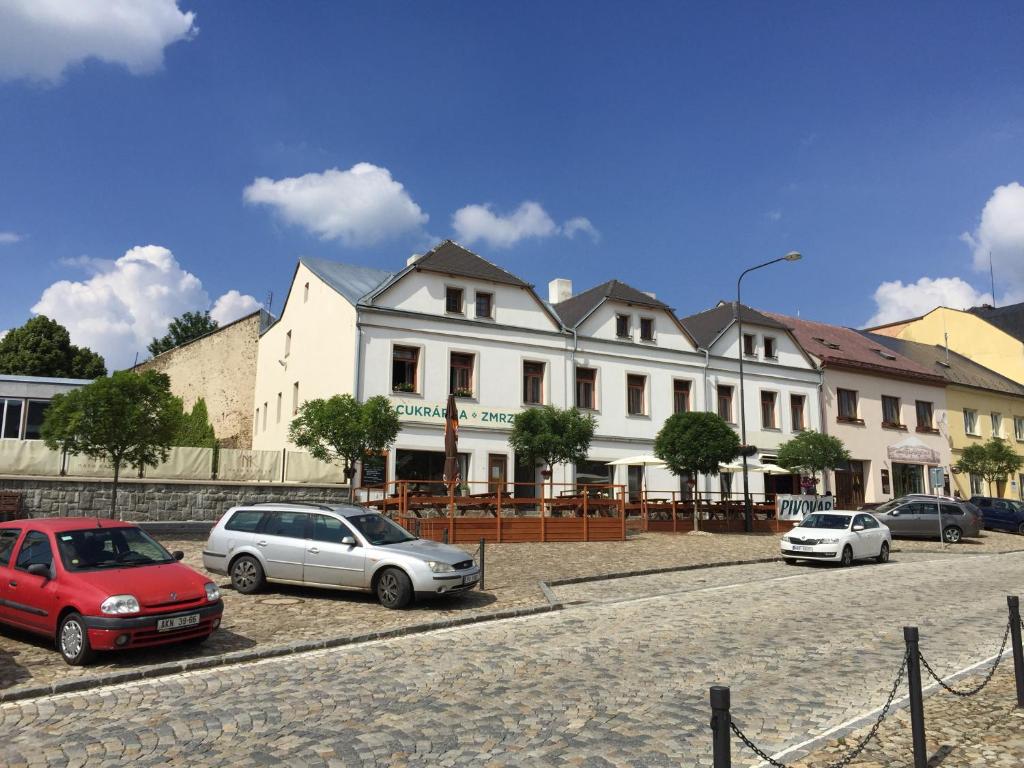 un groupe de voitures garées devant un bâtiment dans l'établissement Apartmány v pivovaru, à Kašperské Hory