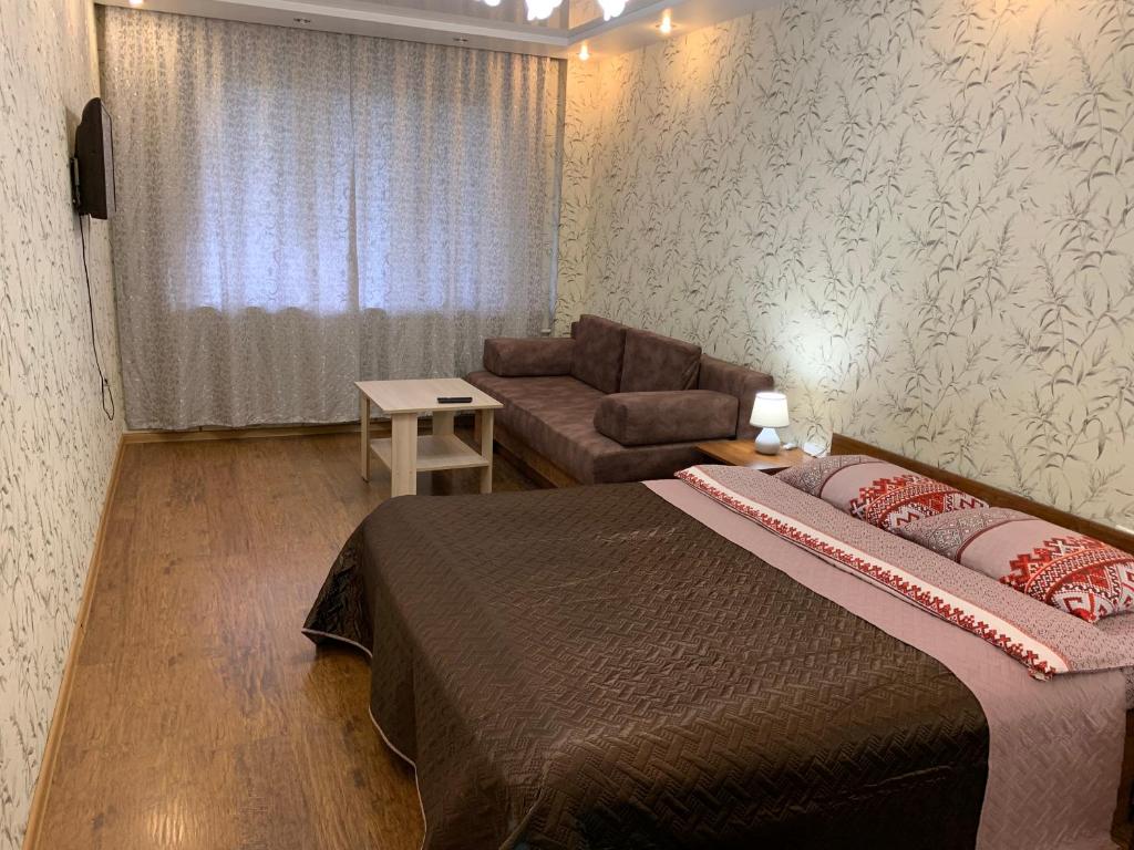 アンガルスクにあるАпартаменты LUX в центреのベッドルーム(大型ベッド1台、ソファ付)