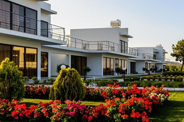 a large white building with flowers in front of it at Cosmopolis Multi-Venue in Larnaca
