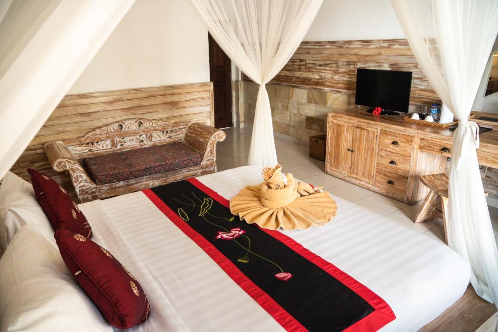 a bedroom with a bed with a dress on it at Alam Terrace Cottages in Ubud