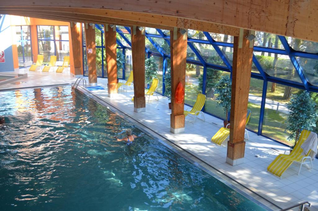 una piscina con sillas amarillas en un edificio en Ośrodek Wypoczynku i Rekreacji Venus, en Mrzeżyno