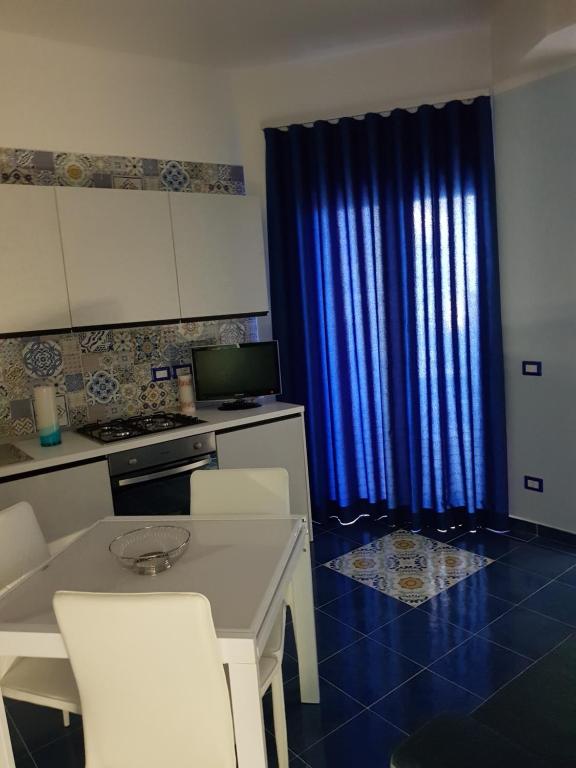 a kitchen with a blue curtain and a table and chairs at BLU SEA SORRENTO in Sorrento