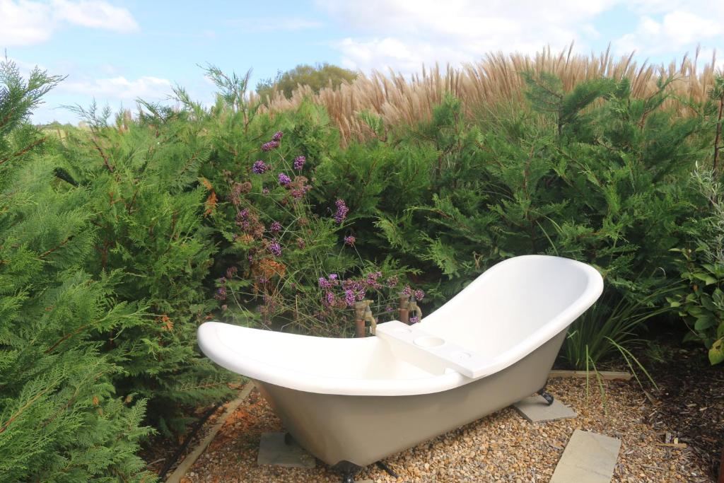 a bath tub sitting in front of some plants at Luxurious Escape,Matakana in Matakana