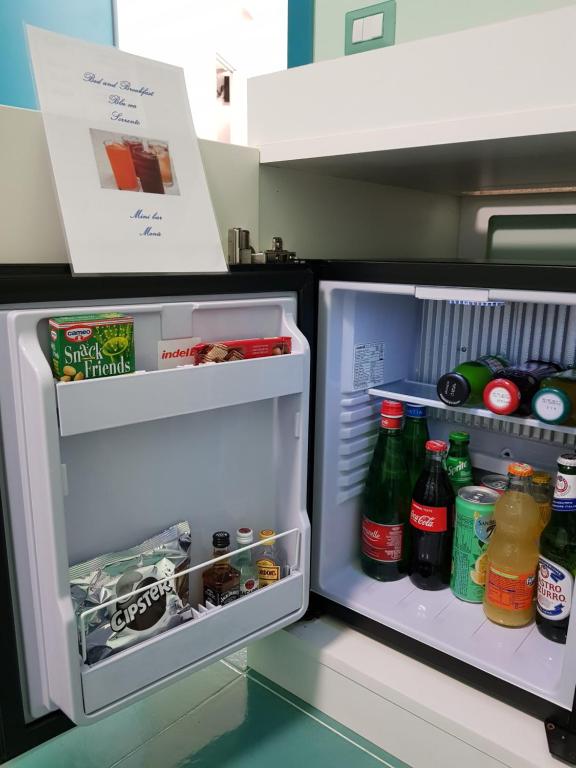 a refrigerator with its door open with food and drinks at BLU SEA SORRENTO in Sorrento