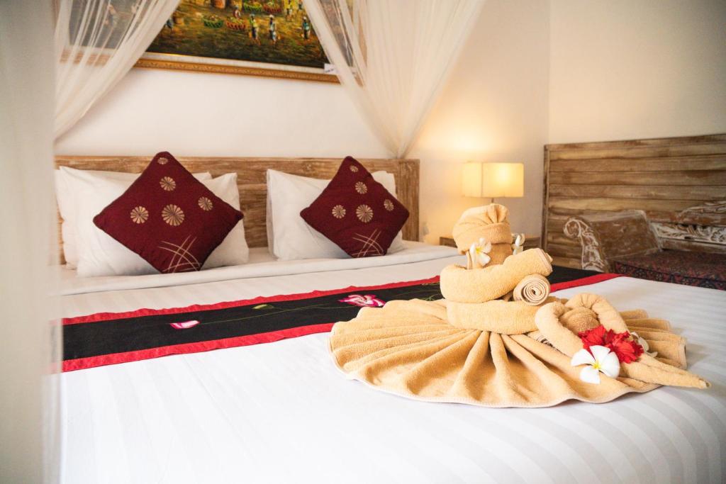 a bedroom with a bed with a stuffed animal on it at Alam Terrace Cottages in Ubud