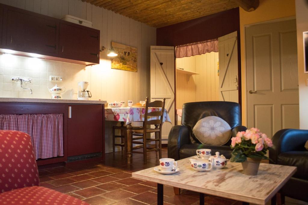 a living room with a table and chairs and a kitchen at Nuuverstee in Borger