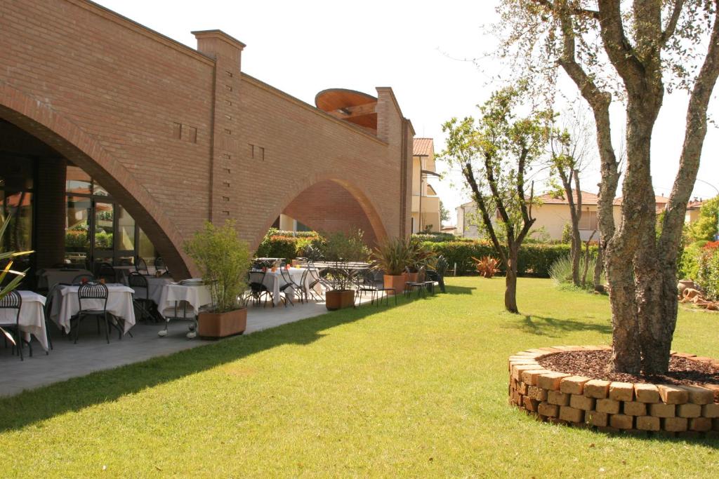 un patio con mesas y sillas y un edificio en Ariete, en Ponsacco